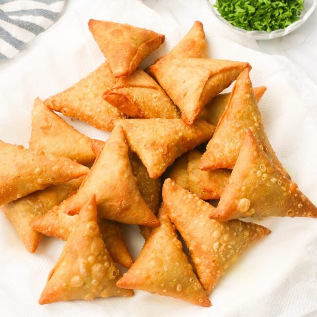 Enjoying a plate of freshly fried sambusas with dipping sauce