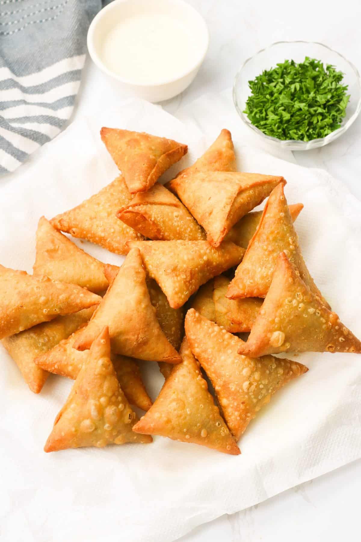 Enjoying a plate of freshly fried sambusas with dipping sauce