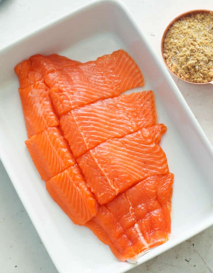 sliced Salmon on a dish with brine mix on the side