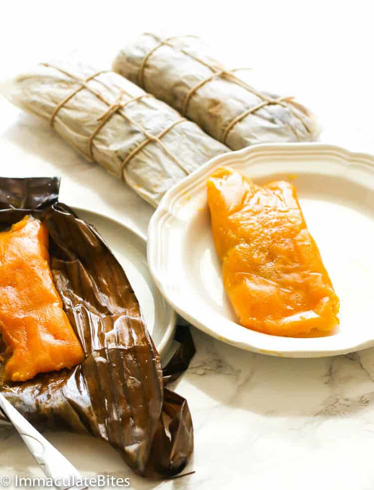 Puerto Rican Pasteles ready to unwrap, with one already on the plate and ready to enjoy