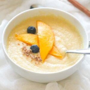 Jamaican cornmeal porridge with mango slices and blueberries