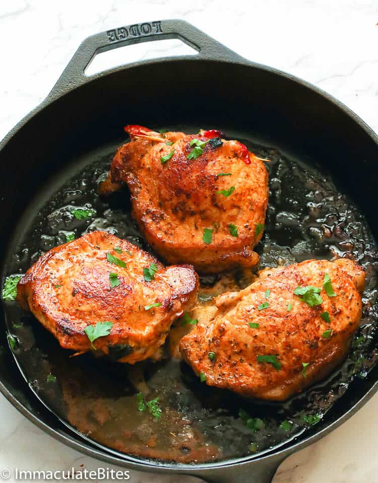 Stuffed Pork Chops hot from the oven  in a cast iron skillet ready to enjoy