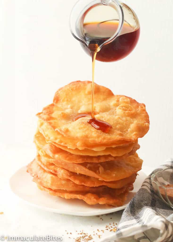 Buñuelos drizzling piloncillo syrup