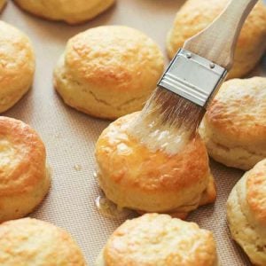 Brushing fresh-from-the-oven angel biscuits with butter