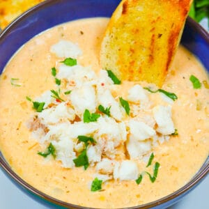 Dipping crusty bread into a steaming hot bowl of she crab soup