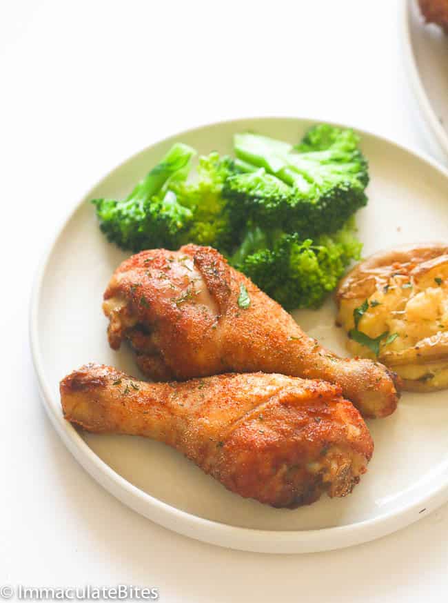 Crispy baked chicken legs with blanched broccoli for a healthy dinner