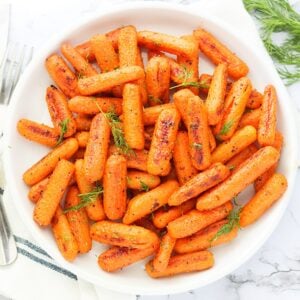 Naturally sweet Roasted Baby Carrots served up on a white plate ready to enjoy