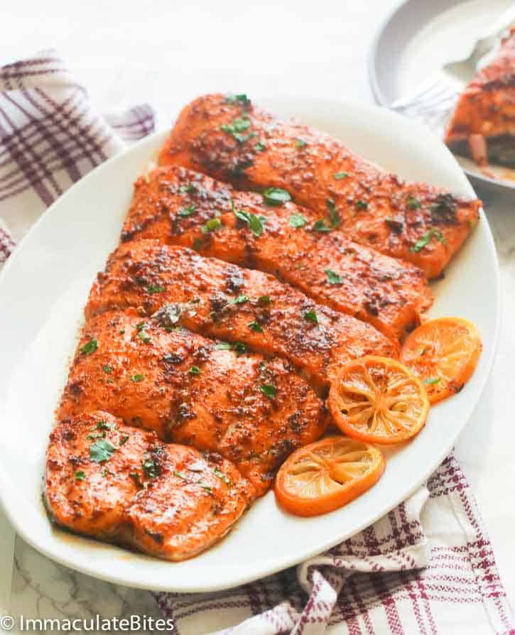 Flavor-packed fish on a white platter decorated with lemon slices