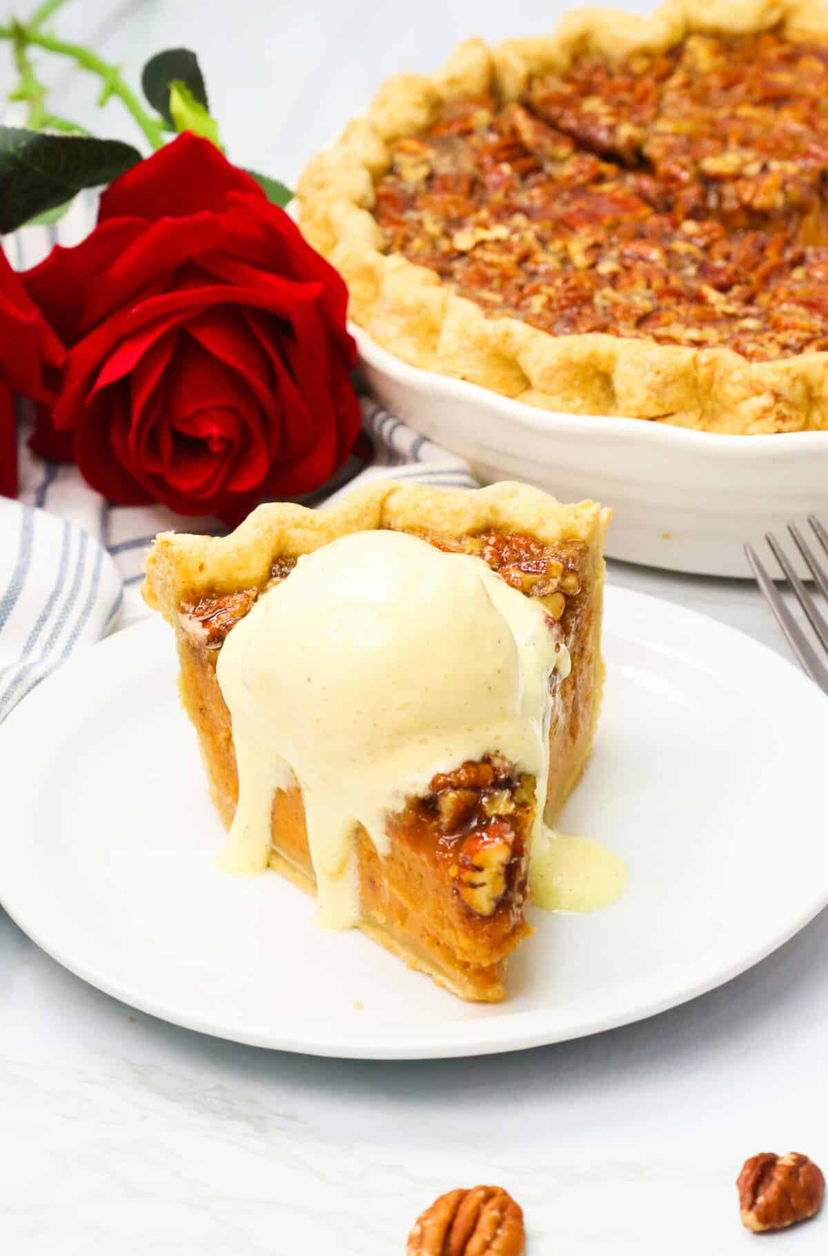 A slice of decadent sweet potato pecan pie topped with vanilla ice cream