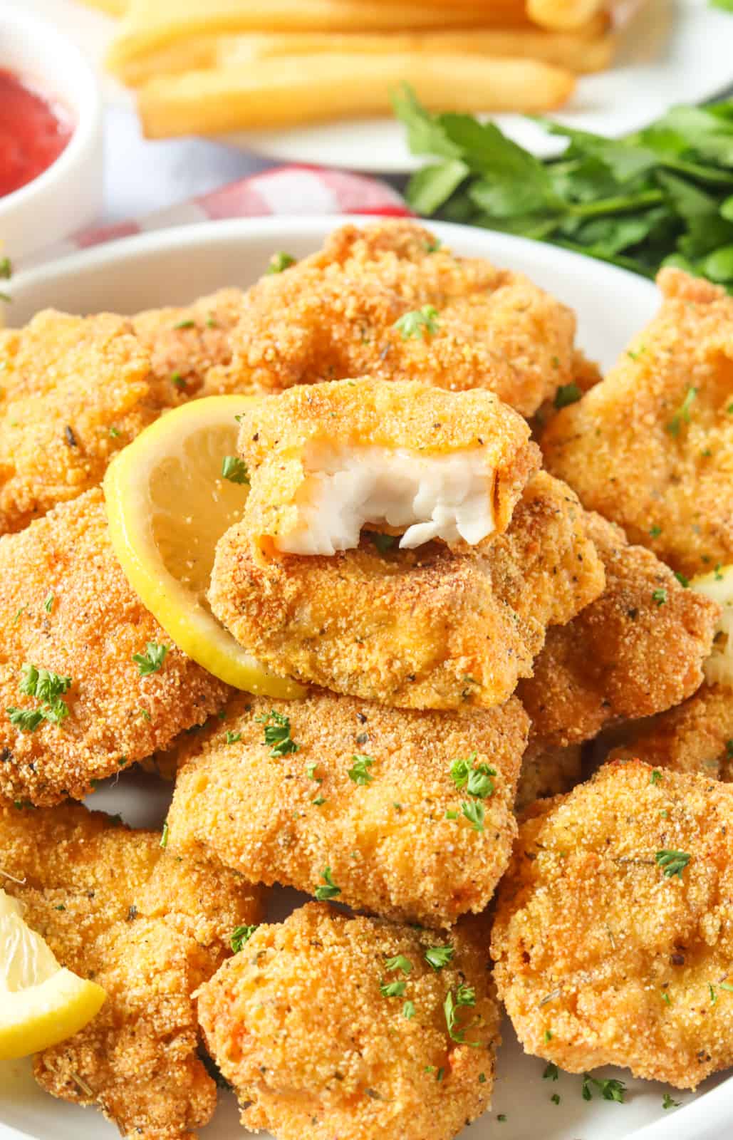 Enjoying a bite-sized catfish nugget and showing off the tender flaky insides