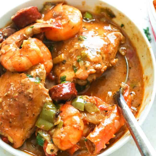 a bowl of gumbo dish with a spoon to scoop it out